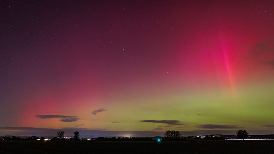 Farbenfrohe Polarlichter über einer Landschaft bei Nacht.