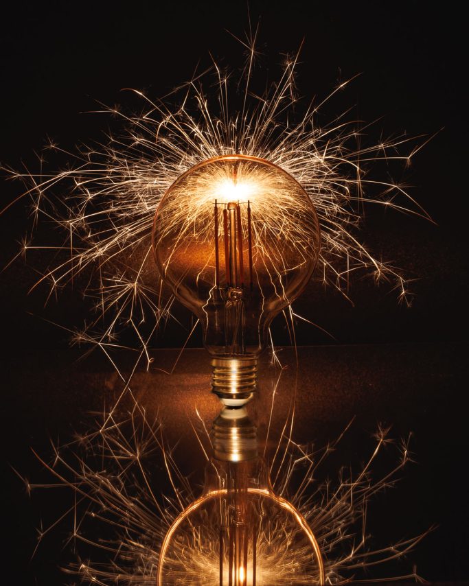 Glühbirne mit funkelndem Licht und reflektierender Oberfläche.